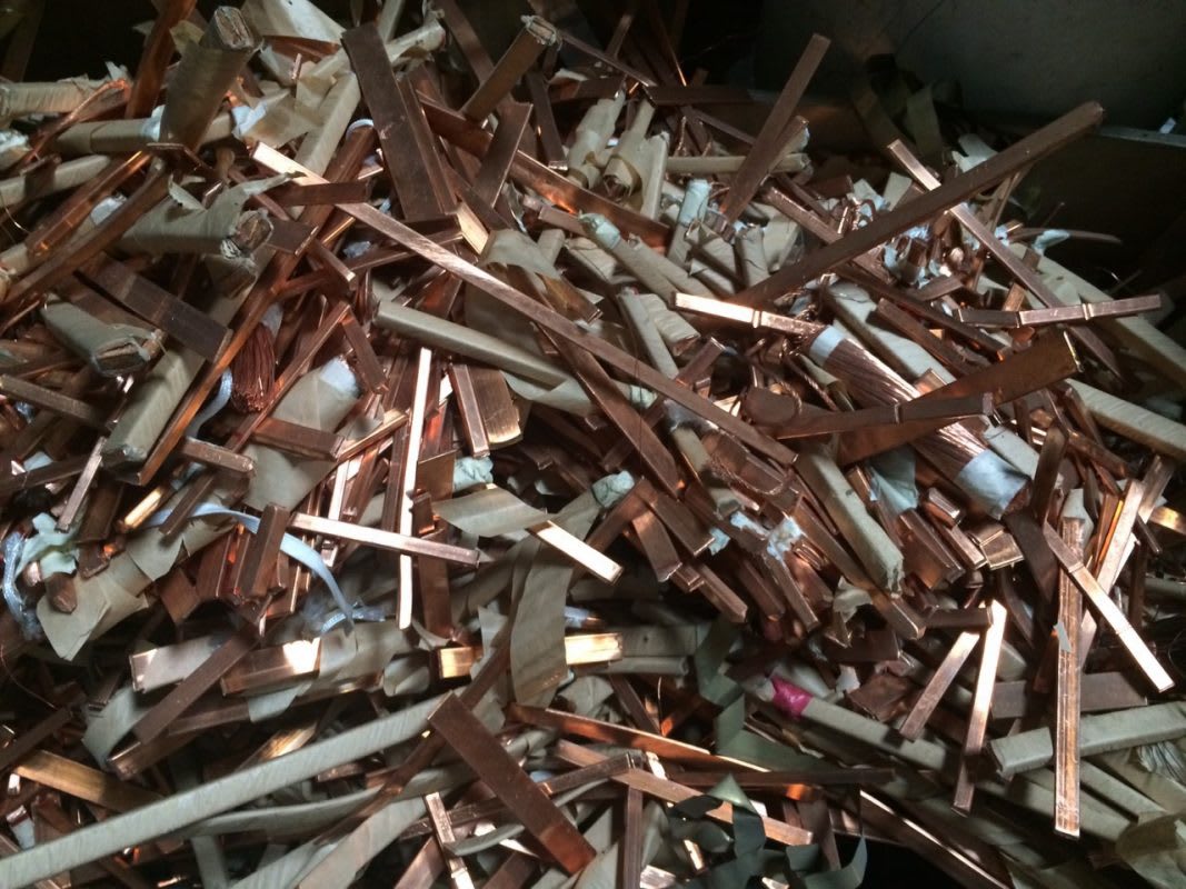 A large pile of red copper scrap pieces wrapped in paper, depicting typical materials collected in the scrap copper industry